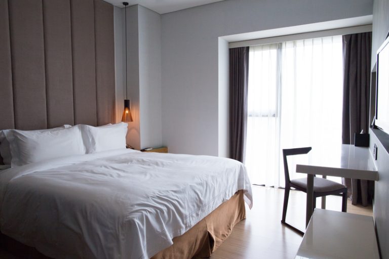 Hotel bedroom with double bed, table and TV set