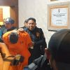 Buronan Interpol Costinel-Cosmin Zuleam menunduk saat digiring ke mobil tahanan di Polda Bali, Selasa (20/1/2026). (Foto: Abid Ahmad Ibrahim/detikBali)