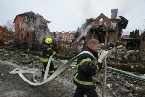 Petugas pemadam kebakaran memadamkan api setelah sebuah drone menghantam bangunan tempat tinggal selama serangan udara Rusia di Kyiv, Ukraina, Minggu, 22 Februari 2026. (Foto AP/Sergei Grits)