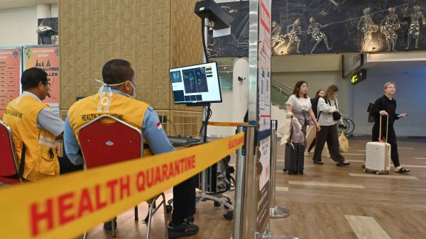 Petugas Balai Besar Kekarantinaan Kesehatan Kelas I Denpasar memantau suhu tubuh penumpang menggunakan alat pemindai suhu tubuh yang terpasang di Terminal Internasional Bandara Internasional I Gusti Ngurah Rai Badung Bali Kamis 2912026 Pengelola Bandara Bali bersama dengan instansi terkait melakukan pengawasan secara ketat dan menyeluruh terhadap penumpang yang tiba di Bali dengan memasang sejumlah alat thermal scanner di area kedatangan internasional dan domestik guna mencegah penularan virus Nipah ANTARA FOTOFikri Yusufrwa