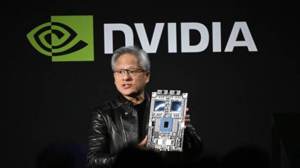 Jensen Huang salah satu pendiri dan CEO Nvidia Corp memegang chip akselerator AI perusahaan untuk pusat data saat berbicara di Nvidia AI Summit Japan di Tokyo Jepang pada hari Rabu 13 November 2024 SoftBank Group Corp akan menjadi pelanggan Nvidia pertama yang membangun superkomputer berdasarkan desain Blackwell baru dari pembuat chip tersebut sebuah langkah untuk memenuhi permintaan yang meningkat di negara yang ingin mengejar ketertinggalan dalam kecerdasan buatan Fotografer Akio KonBloomberg via Getty Images
