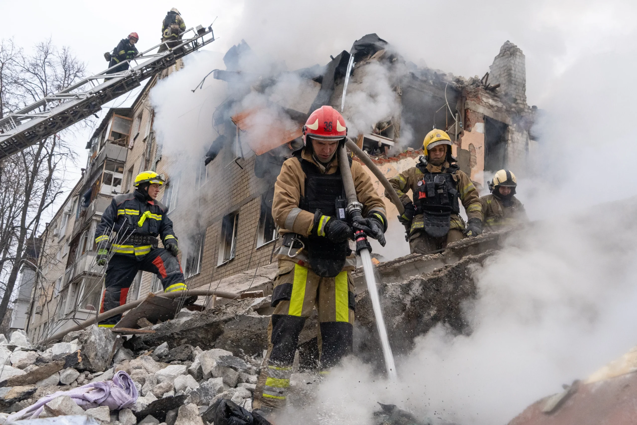 Petugas pemadam kebakaran memadamkan api di reruntuhan gedung apartemen setelah serangan rudal Rusia di Kharkiv, Ukraina, Sabtu, 7 Maret 2026. (Foto AP/Andrii Marienko)