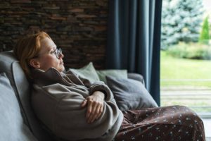 Mid adult woman sitting at home sad and depressed