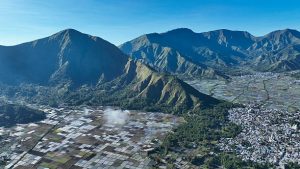 Pemandangan udara sawah mosaik ikonik Sembalun, Lombok Timur dan perbukitan hijau. Foto: iStock/Amed-in-bali