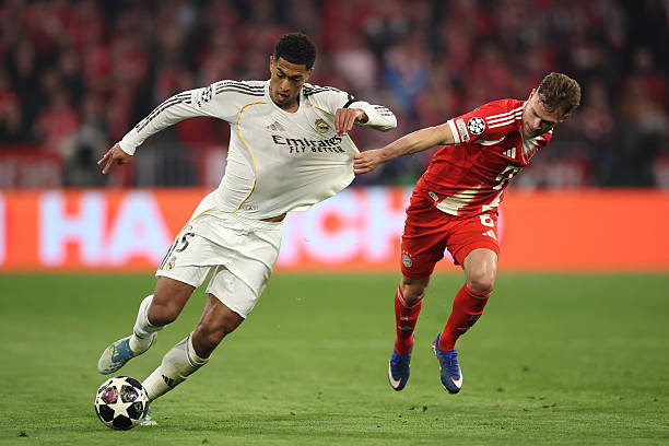 MUNICH, JERMAN - 15 APRIL: Jude Bellingham dari Real Madrid dihalangi oleh Joshua Kimmich dari FC Bayern Munich selama pertandingan leg kedua perempat final Liga Champions UEFA 2025/26 antara FC Bayern München dan Real Madrid CF di Football Arena Munich pada 15 April 2026 di Munich, Jerman. (Foto oleh Alex Grimm/Getty Images)